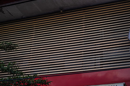 Modern Building Exterior Featuring Geometric Louvers and Red Element