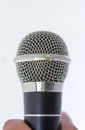 Detailed macro shot of dynamic vocal microphone grille and capsule isolated on bright white background.の写真素材