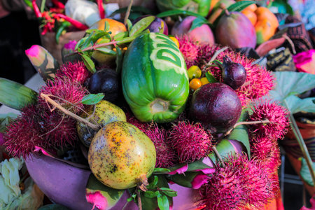 Abundant and colorful composition of exotic Southeast Asian fruits featuring bright pink rambutans,...