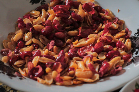 Indonesian snack of caramelized peanuts with red skin in a bowl, presented under natural light, offering ample copy space for food photographyの写真素材