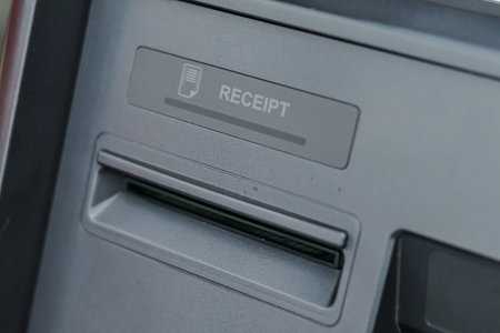 ATM Receipt Slot Close-up Showing Empty Space for Text, Natural Lighting, and Financial Transaction...