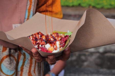 Indonesian Street Food Gado-Gado Being Prepared with Peanut Sauce Drizzle, a Traditional Dish Served...