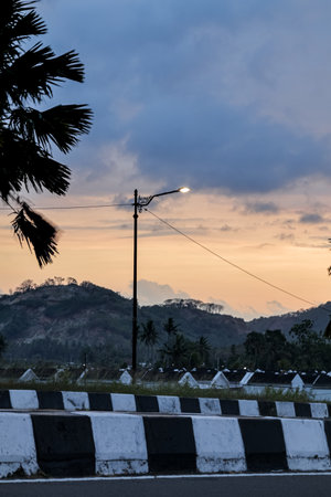 Streetlight illuminating a twilight landscape with mountain backdrop, showcasing urban meets nature,...