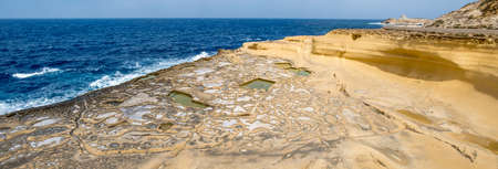 Panorama of Salt evaporation ponds, also called salterns or salt pans located near Qbajjar on the maltese Island of Gozo.の写真素材