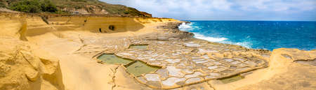 Panoramic view of Salt evaporation ponds, also called salterns or salt pans located near Qbajjar on the maltese Island of Gozo.の写真素材