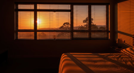 Sunset in the bedroom with double bed and orange blinds.の素材