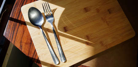 spoon and fork metal on wooden board