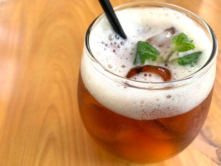 Sparkling citrus tea, organic tea with citrus and soda with hits of mint leaves in a Glass on top of wooden table very refreshingの写真素材