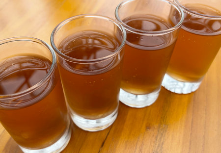 Fresh cold Apple juice in four clear glass with wooden background serves for breakfast