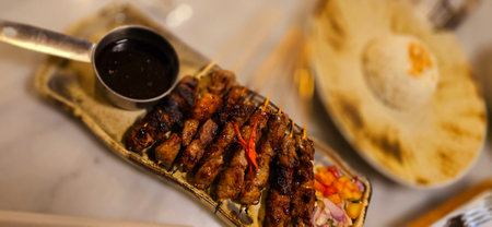 Homemade beef Satay marinated with spice and sweet soy sauce, coriander beef satay, served on plate with onion, chilli, soy sauce and tomato. Indonesian traditional foodの写真素材