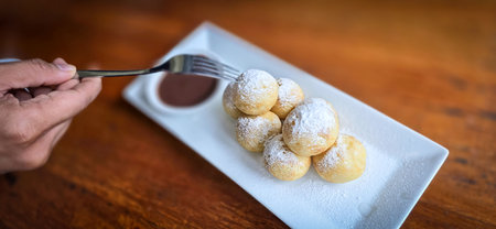 Homemade Dutch poffertjes mini pancakes with icing powdered sugar and chocolate fillings with...