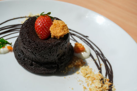 Delicious chocolate fondant or lava cake with cream, strawberry, and cake biscuit crumbles, Hot...