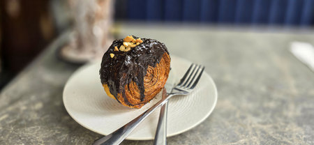Delicious Cromboloni or Crombolini, croissant bomboloni round New York roll with chocolate sauce or...