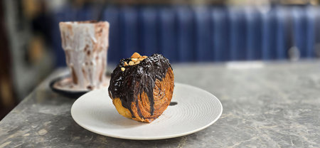 Delicious Cromboloni or Crombolini, croissant bomboloni round New York roll with chocolate sauce or...