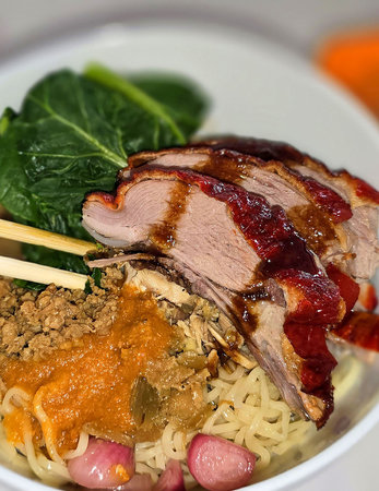 bowl of Cantonese peking roast duck with crispy skin and tender meat, served fresh noodle soup along with plum sauce on the side, capturing the savory flavors and best culinaryの写真素材