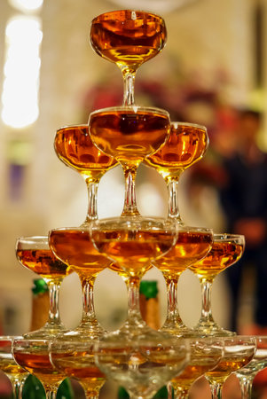 glasses of champagne or wine glasses in a luxurious atmosphere. Stylish, toned photo, secular reception, new year, wedding, sparkling champagne glasses flutes close up with bottles in dark backgroundの写真素材