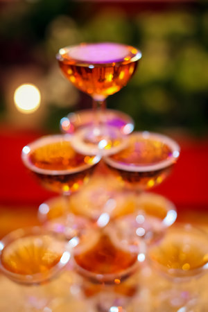 glasses of champagne or wine glasses in a luxurious atmosphere. Stylish, toned photo, secular reception, new year, wedding, sparkling champagne glasses flutes close up with bottles in dark backgroundの写真素材