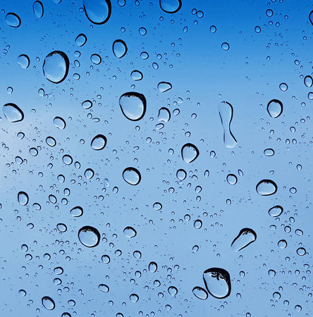 Rain and water droplets perspective through window glass surface against blue sky good for...