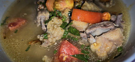 Bowl of hearty traditional lamb or mutton meat soup featuring chunks of meat and fresh vegetables, and a wedge of lime, perfect for enjoying a comforting and flavorful meal good for recipe bookの写真素材