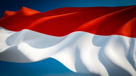 Indonesian flag waving the red and white flag represents symbol of courage and purity, picture the flag of Indonesia with its red symbolizing courage and bravery, and white symbolizing purity and peace good for multimedia content creationの写真素材