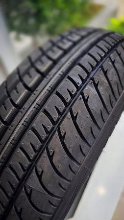 detailed image of a brand new car tire showcasing its intricate tread pattern for enhanced grip and...
