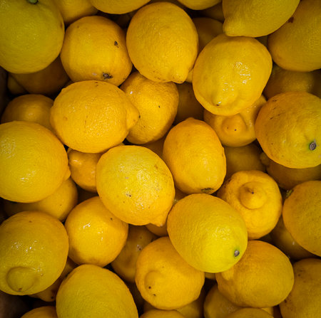 Bright yellow lemons grouped together, presenting an inviting and fresh appearance suitable for...