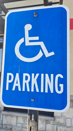 blue parking sign featuring a universal symbol for accessibility and the word PARKING. Highlights...
