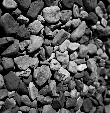 texture of a natural assortment of pebbles and river stones in warm earth tones, ideal for landscaping, garden borders, pathways, or decorative rock surfaces. Natural Pebbles And River Stones For Landscaping And Garden Decorの写真素材