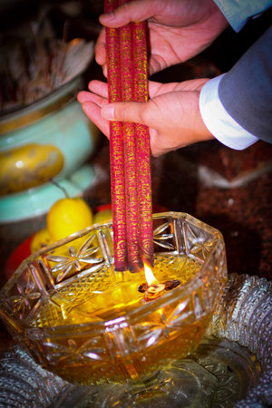 Pray in a Temple as Incense Sticks Burn, Creating a Colorful Ceremonial Scene,Chinese prayer, Chinese new year prayersの写真素材