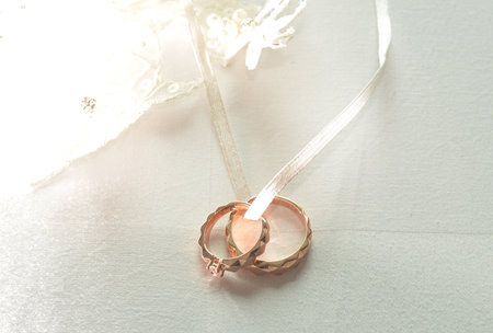 Elegant precious Diamond wedding Rings Resting On Surface With Blurred Backdrop For Wedding ceremonyの写真素材