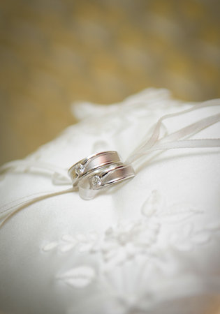 Elegant precious Diamond wedding Rings Resting On Surface With Blurred Backdrop For Wedding ceremonyの写真素材