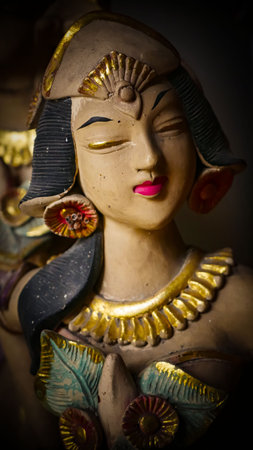 serene Bali dancer ceramic bust featuring closed eyes, bright lips, and gold embellishments. Ideal...