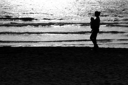 woman with child walking on the beachの写真素材