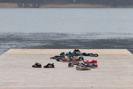 On the pier at the lake are sneakers that left rowers.の写真素材