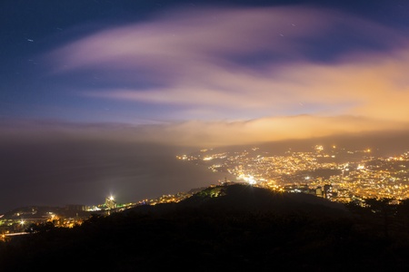 Night city light with clouds and seaの写真素材