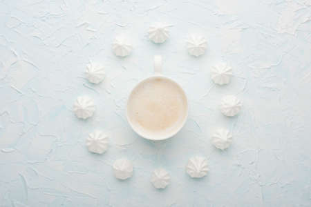 Time coffee with coffee cup and meringue on a light backgroundの写真素材