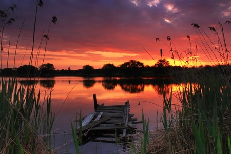 Old fishing bridge on the lake at sunset の写真素材
