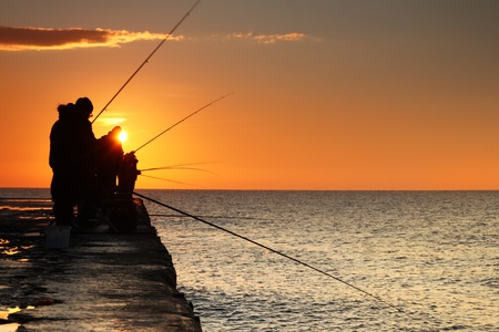 Fishermen at sunrise on the seaの写真素材