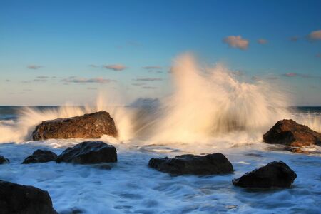 Storm waves on the sunriseの写真素材