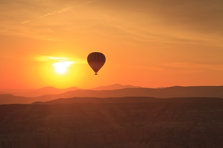 Hot air balloon is flying at sunrise の写真素材