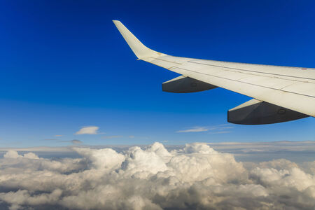 View of the clouds and airplane wing from the Inside