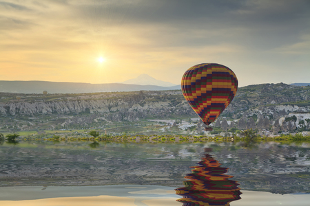 Reflection balloon flying in the lake at sunset.の写真素材