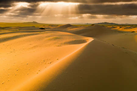 Sunset over the sand dunes in the desert. Arid landscape of the Sahara desertの写真素材