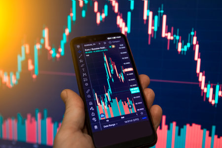 Man analyse stock market using mobile smart phoneの写真素材