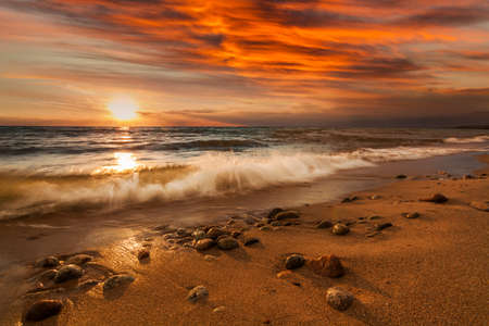 Sunset on the rocky shore of tropical sea. Summer vacation on tropical resortの写真素材