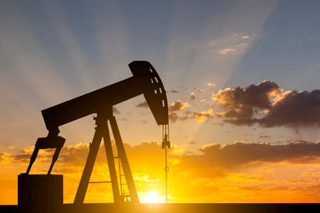 Oil pump at sunset background. Oil industry equipment.