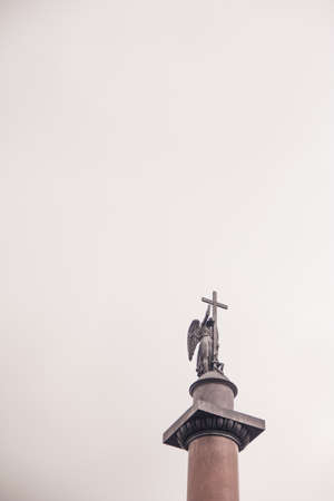 statue of an angel holding a cross against the skyの写真素材