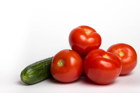 A few tomatoes and cucumber on a white backgroundの写真素材