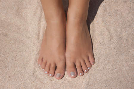women's feet and hands on the beach beautiful skinの写真素材