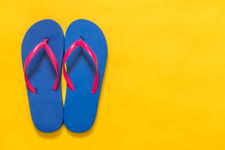 Travel vacation background. Flip flops on a yellow background. Flat layの写真素材